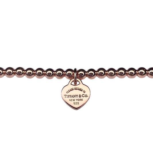 Tiffany & Co. heart pendant on a  unbranded ball bracelet in roségold