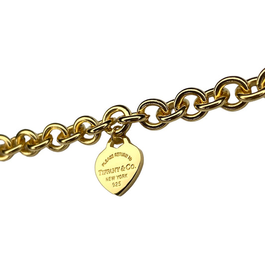 Tiffany & Co. gold heart pendant on an unbranded link bracelet, adjustable